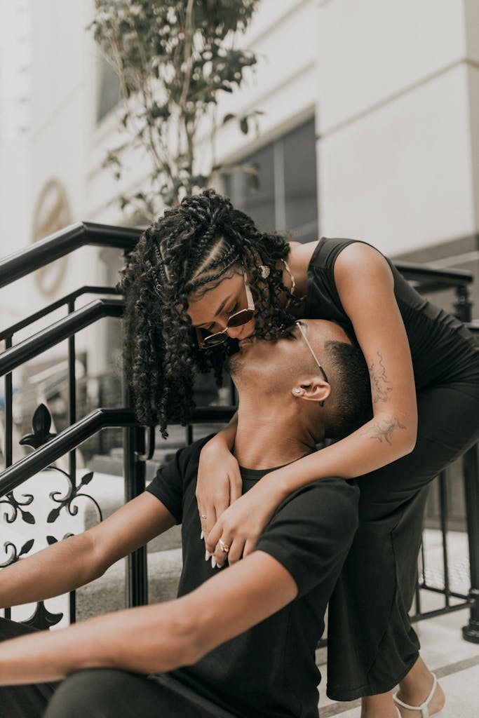 A loving couple shares a joyful embrace on a city street, showcasing urban romance and connection.
