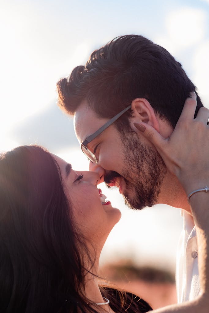 A loving couple sharing an intimate moment outdoors at sunset. Capturing genuine affection.