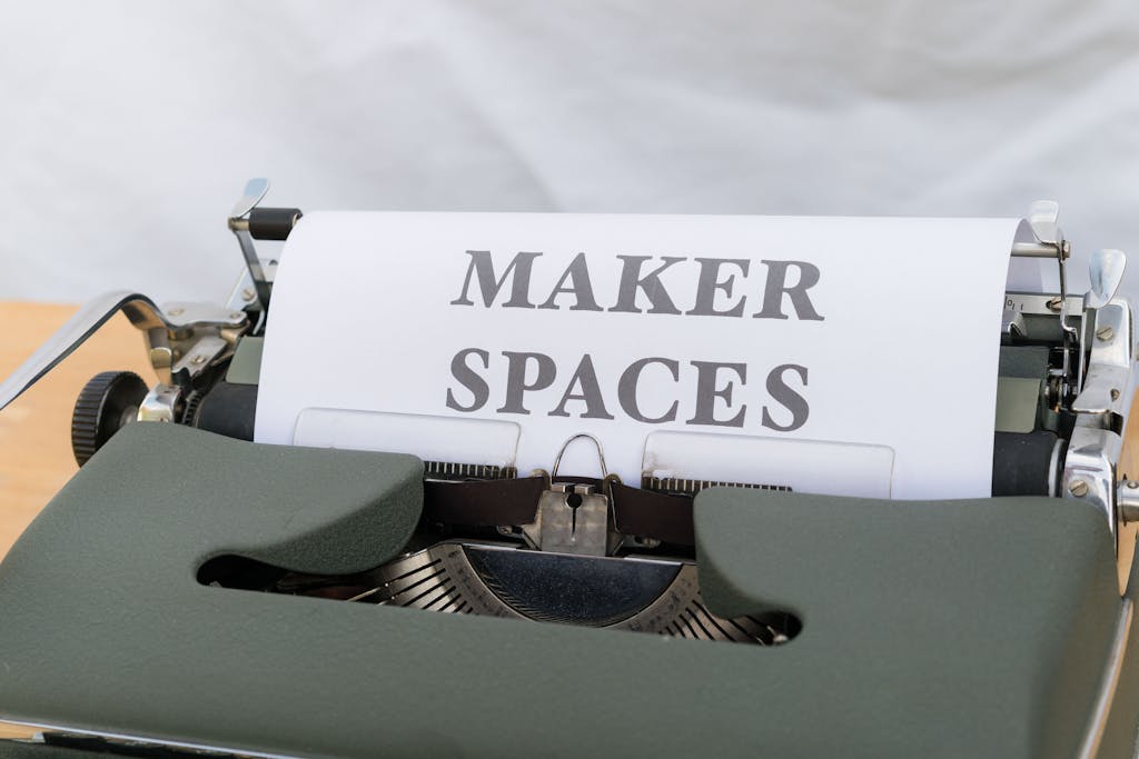 Close-up of a vintage typewriter with a paper reading 'Maker Spaces,' ideal for educational and creative content.